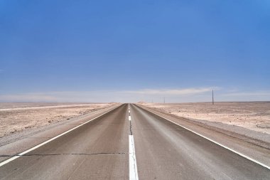 Güney Amerika 'daki Atakama Çölü' nde hiçliğe açılan karanlık, siyah asfalt yol. 