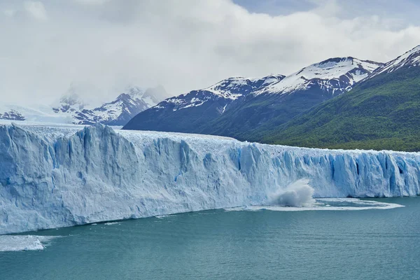 アルゼンチンのパタゴニアの氷河国立公園にあるペリト モレノ氷河の青い氷 前景のラゴ アルゼンチーノのターコイズブルーの水 遠くのアンデスの濃い緑の森 — ストック写真