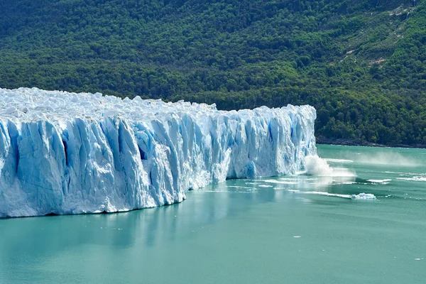 アルゼンチンのパタゴニアの氷河国立公園にあるペリト モレノ氷河を氷のように氷のように氷の上にはターコイズブルーのラゴ アルゼンチンの水が前景にあり 濃い緑の森が広がり 遠くにアンデス山脈の山が広がっています — ストック写真