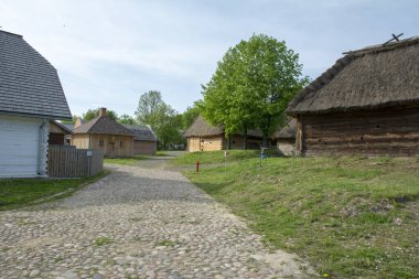 Açık hava müzesi, sazdan çatı, köy, kırsaldaki yol, kenar, yeşillik, eski kır evi, eski ahşap kütükler, köyde bir bank.