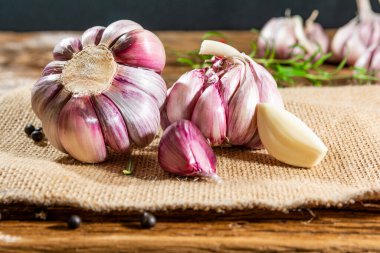 Sarımsak soğanları ve karanfiller eski bir tahtaya dizilmiş..