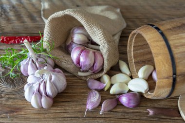 Sarımsak soğanları ve karanfiller eski bir tahtaya dizilmiş..