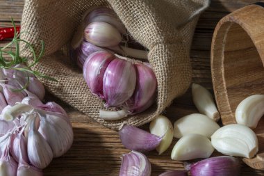 Sarımsak soğanları ve karanfiller eski bir tahtaya dizilmiş..