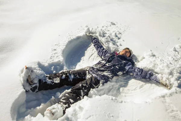 Donna felice che fa angelo di neve nella neve — Foto Stock