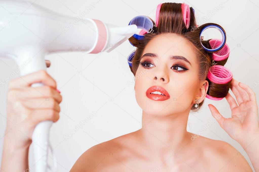 Young girl drying hair by hairdryer