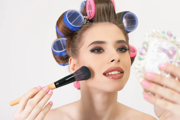 Junges Mädchen macht Make-up und Frisur mit Lockenwicklern — Stockfoto