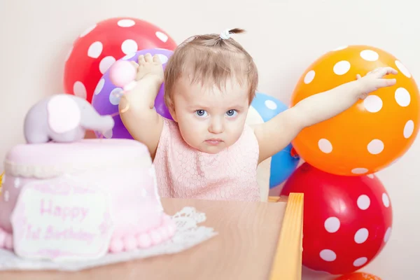 Funny baby celebrating first birthday. Cake.