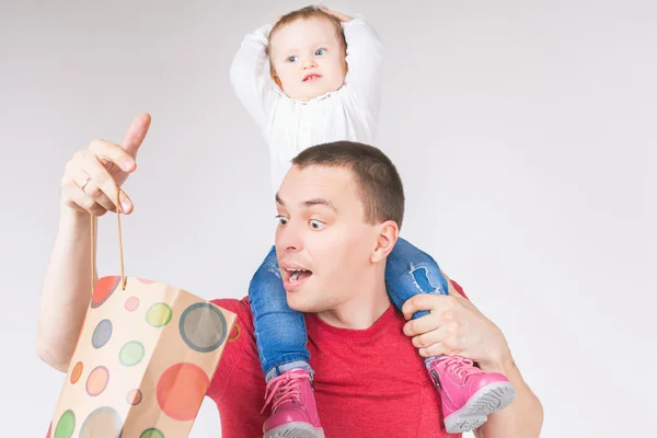 Здивований батько і смішна дитина тримає сумки з покупками — стокове фото