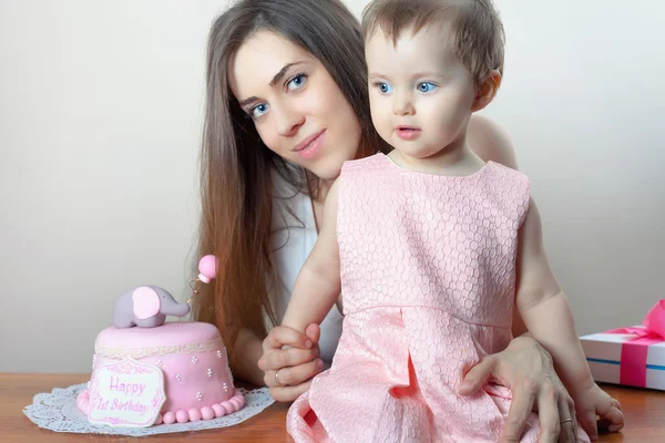 Mother with funny baby celebrating first birthday. Cake.