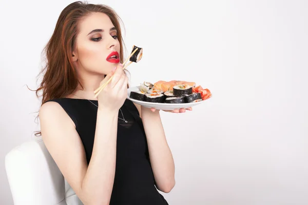 Young woman eating sushi at Japanese restaurant