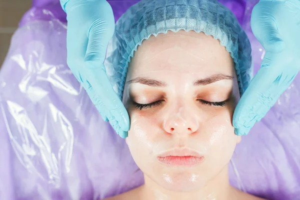 Kobieta w salonie spa leczonych twarz kremem twarzy — Zdjęcie stockowe