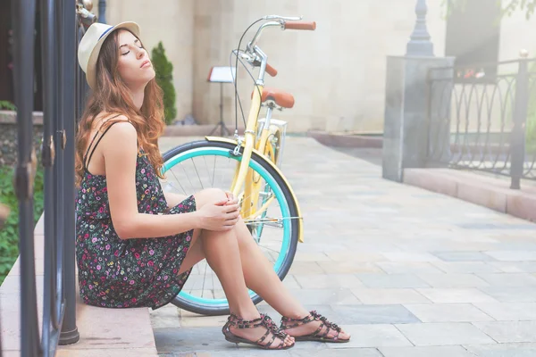 Young girl sitting near vintage bike at park — Stock Photo, Image