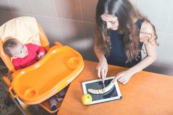 Мать готовит детское питание на компьютерном столе — стоковое фото