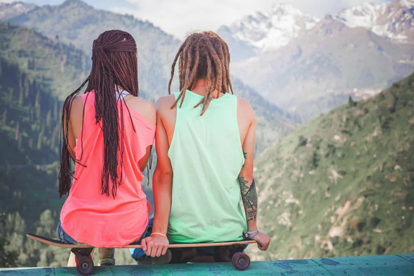 Hippie-Paar, junge Leute am Berg mit Longboard-Skatebord — Stockfoto