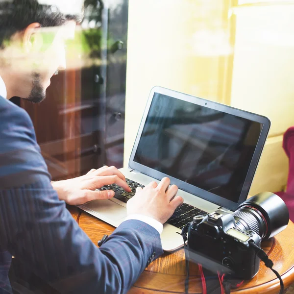 Giovane fotografo che lavora al caffè, utilizzando il computer portatile — Foto Stock