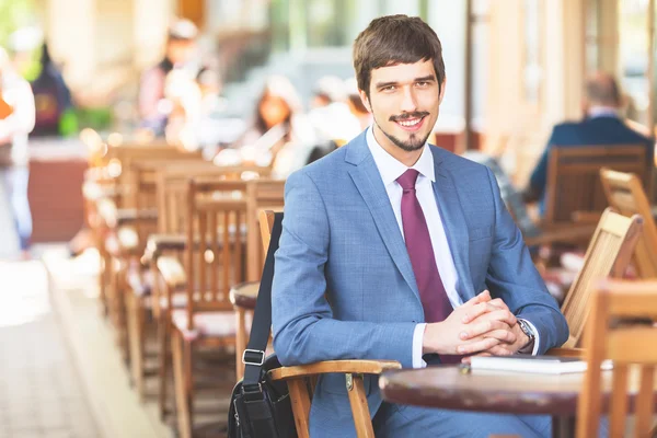 Handsome male has a french breakfast at sidewalk cafe — Stock Photo, Image