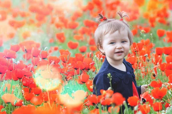 Funny child holding a balloon outdoor at poppy field