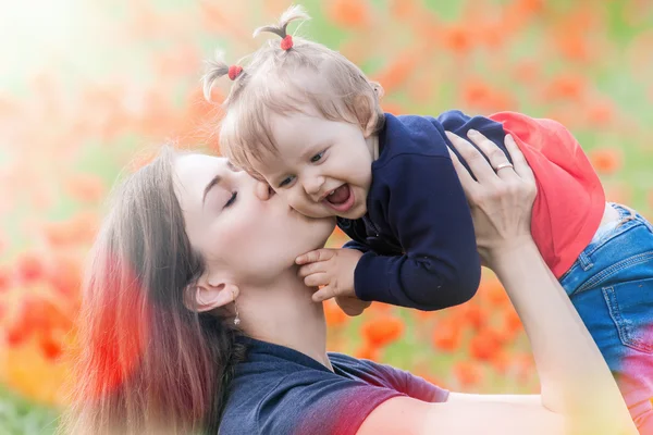 Madre con divertente bambino all'aperto al campo di fiori di papavero — Foto Stock