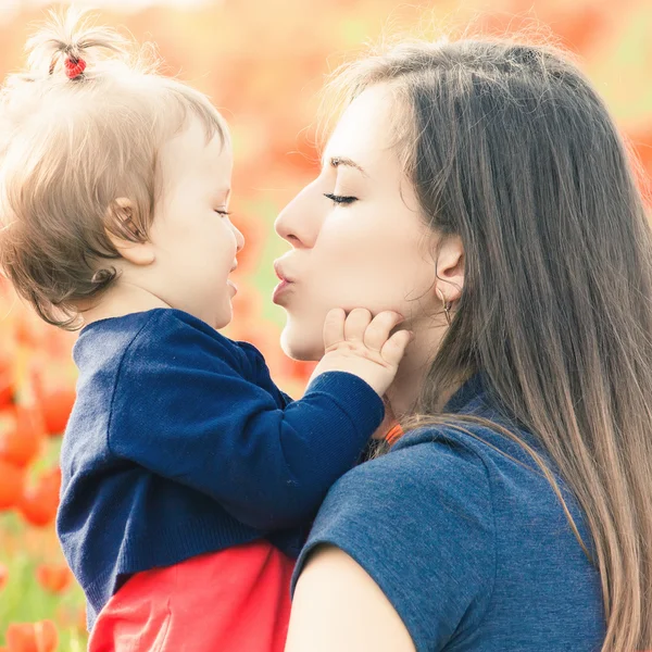 Madre con niño divertido al aire libre en el campo de flores de amapola —  Fotos de Stock