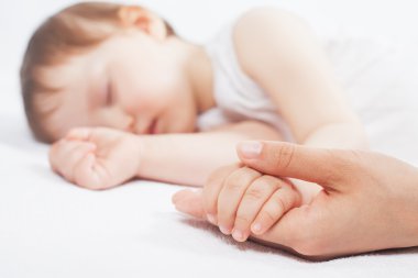 Yeni doğan bebek tatlı beyaz bir yatakta uyumak