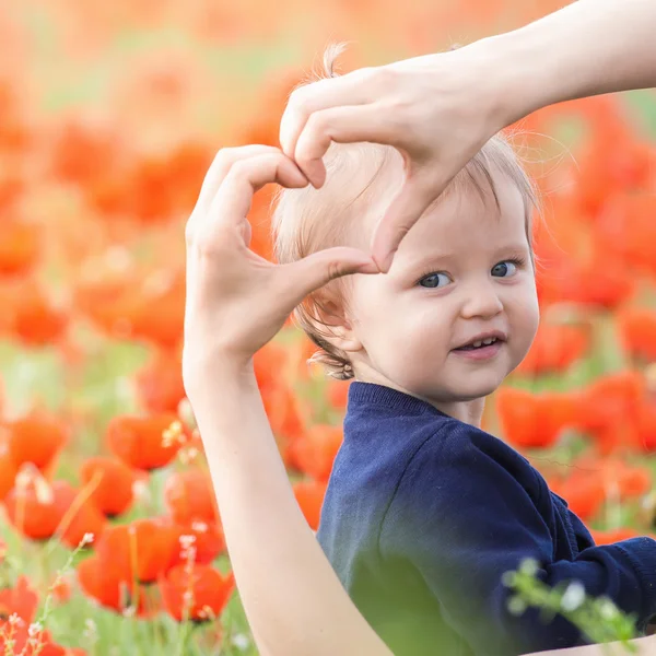 Madre con niño divertido al aire libre en el campo de flores de amapola —  Fotos de Stock