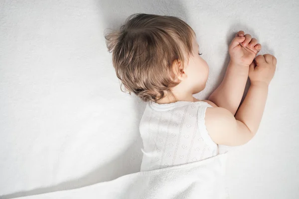 Újszülött édes fehér ágyban alszik — Stock Fotó