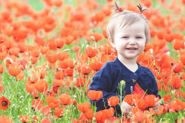 Bir balon haşhaş sahasında açık tutarak komik çocuk