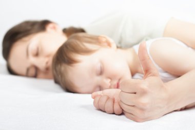 Yeni doğan bebek tatlı beyaz bir yatakta uyumak