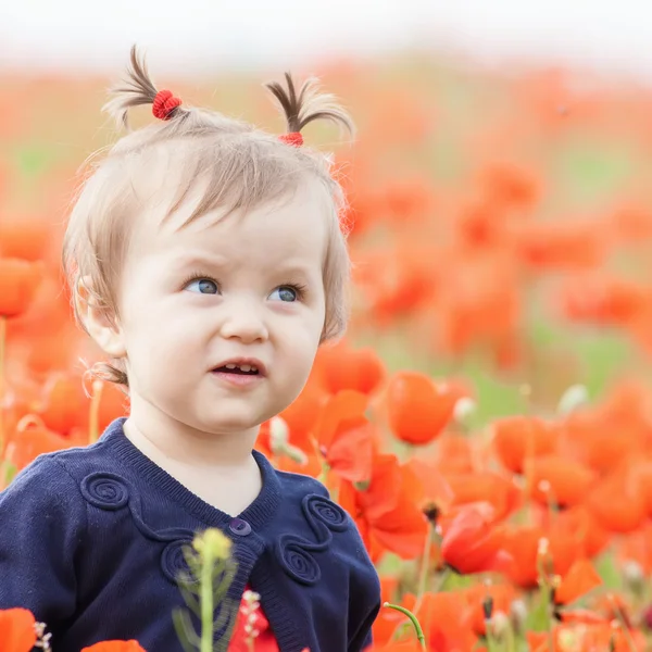 Funny child holding a balloon outdoor at poppy field — Stock Photo, Image