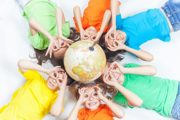 Grupp internationella funny kids med globe jord — Stockfoto