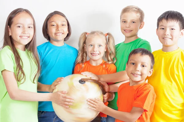 Grupo de niños internacionales sosteniendo globo terráqueo — Foto de Stock