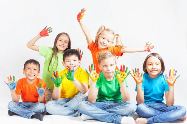 Happy kids with painted hands smiling