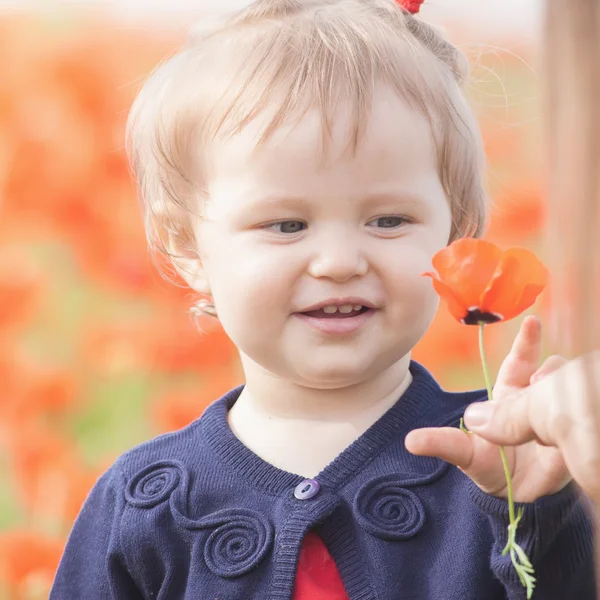 Funny child holding a balloon outdoor at poppy field — Stock Photo, Image