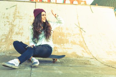 Harika kaykaycı kız kaykay skatepark oturan açık ile