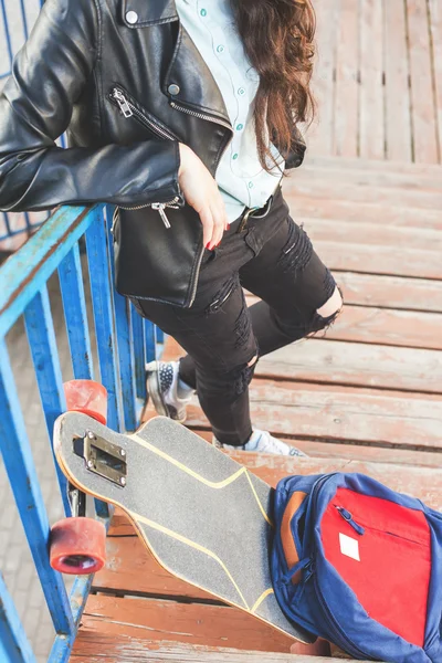 Hipster skateboarder meisje met skateboard permanent buiten — Stockfoto