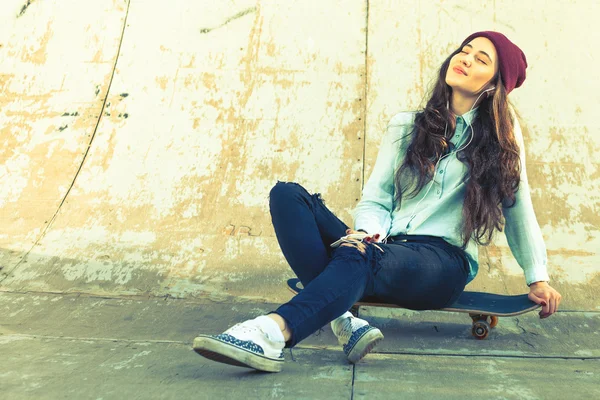 Impresionante skateboarder chica con monopatín al aire libre sentado en skatepark — Foto de Stock