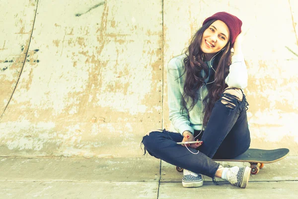Hipster Skater girl z deskorolka odkryty, siedząc w skateparku — Zdjęcie stockowe