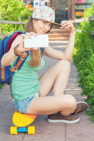 Awesome skateboarder girl making selfie on mobile phone — Stock Photo, Image