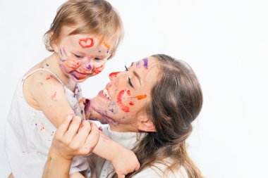 Mutlu anne ve bebek ile boyalı yüz boya ile oynarken