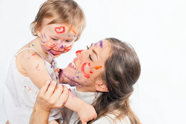 Mutlu anne ve bebek ile boyalı yüz boya ile oynarken