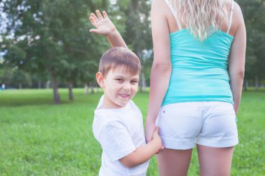 Anne oğluyla açık yürüyüş. Çocuk elini sallayarak.