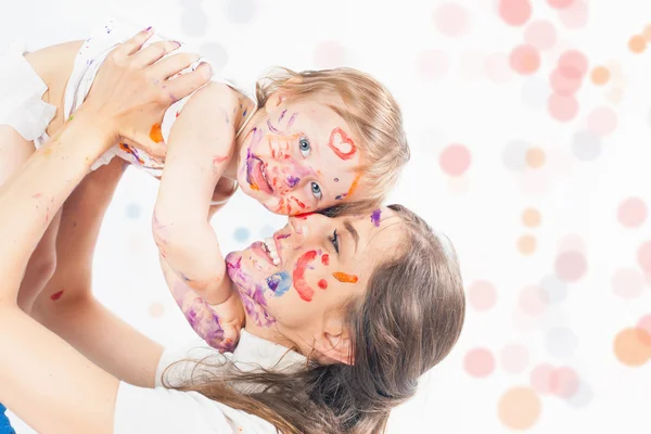 Mama fericita si copilul se joaca cu fata pictata de vopsea — Fotografie, imagine de stoc