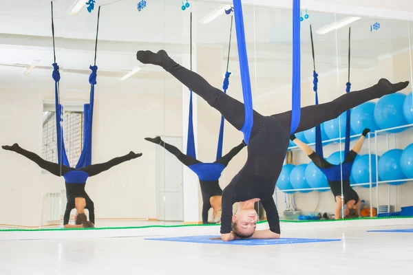 Mujeres jóvenes haciendo ejercicio de yoga aéreo o yoga antigravedad —  Fotos de Stock