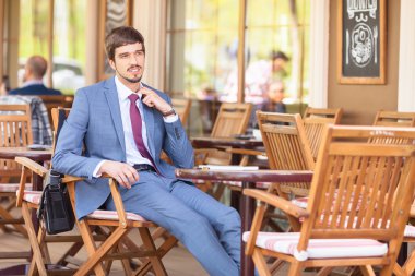 İşadamı açık kafede oturan bir rahatsızlık hissediyor