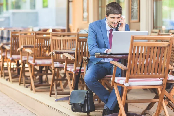 Framgångsrik man händerna upp utomhus på café — Stockfoto