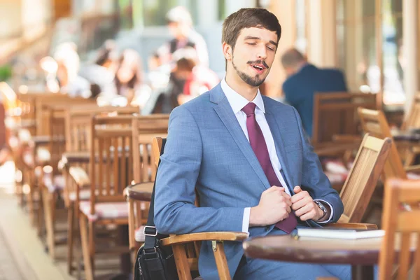 Handsome male has a french breakfast at sidewalk cafe — Stock Photo, Image