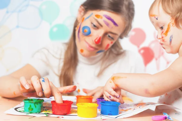 Máma a dítě nakreslí barvou barevných inkoustů — Stock fotografie