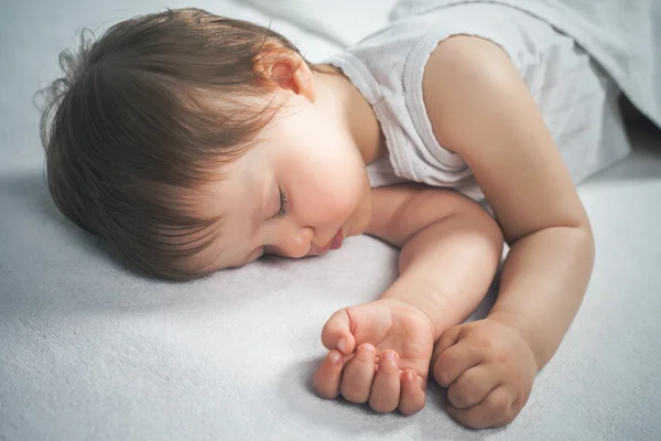 Bebê recém-nascido doce dormindo em uma cama branca — Fotografia de Stock