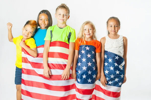 Grupa dzieci szkolnych posiadających amerykańską flagę narodową — Zdjęcie stockowe
