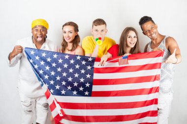 Grup bir Amerikan bayrağı tutarak çok ırklı insan
